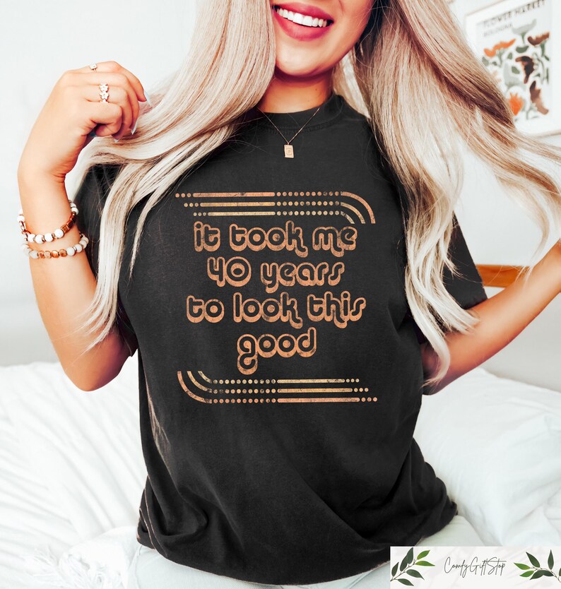 May include: Black t-shirt with a gold graphic that says "It took me 40 years to look this good".