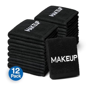 May include: A stack of 12 black makeup remover towels with white embroidery that says "MAKEUP". The towels are folded and stacked on a white background. The text "12 Pack" is on a blue circle.