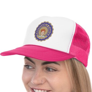 May include: A pink and white trucker hat with a blue and gold patch that says "Classifiably Ginger".