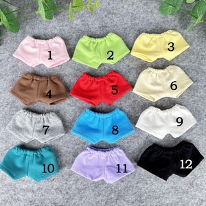 Puede incluir: Una colecci&oacute;n de doce pares de shorts en miniatura en varios colores, incluyendo rosa, verde, amarillo, marr&oacute;n, rojo, crema, gris, azul, blanco, turquesa, morado y negro. Cada par est&aacute; numerado del 1 al 12.