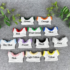 May include: A collection of miniature white t-shirts with colored trim and text labels. Colors include green, orange, red, fruit green, blue, sky blue, purple, black, grey, pink, light yellow, and yellow.