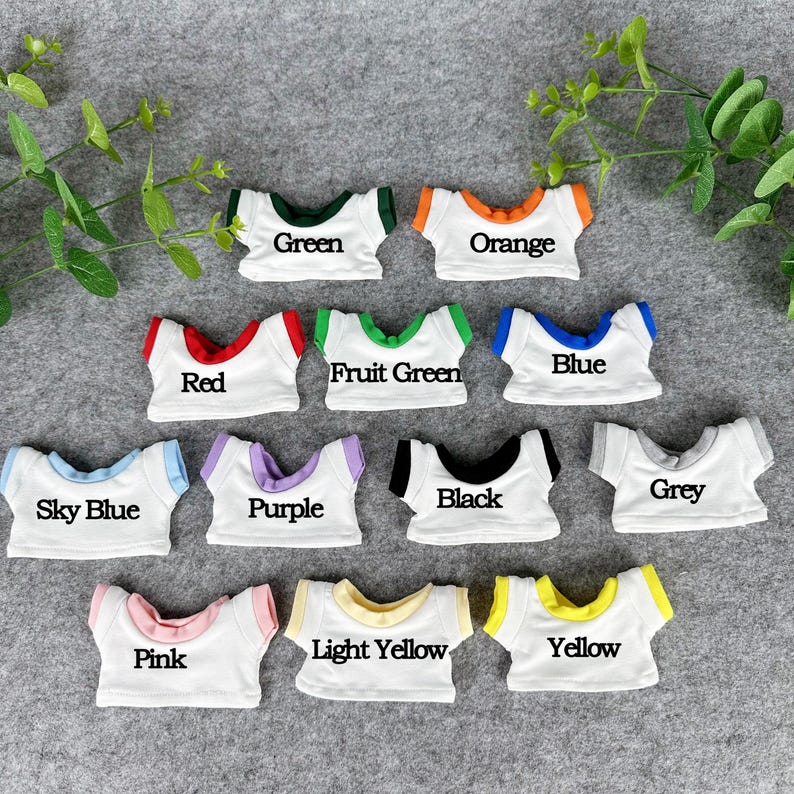 May include: A collection of miniature white t-shirts with colored trim and text labels. Colors include green, orange, red, fruit green, blue, sky blue, purple, black, grey, pink, light yellow, and yellow.