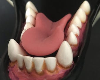 Könnte beinhalten: Nahaufnahme einer rosa Zunge, die aus einem Mund mit weißen Zähnen herausragt. Der Mund ist weit geöffnet und die Zunge ist nach oben gerollt.