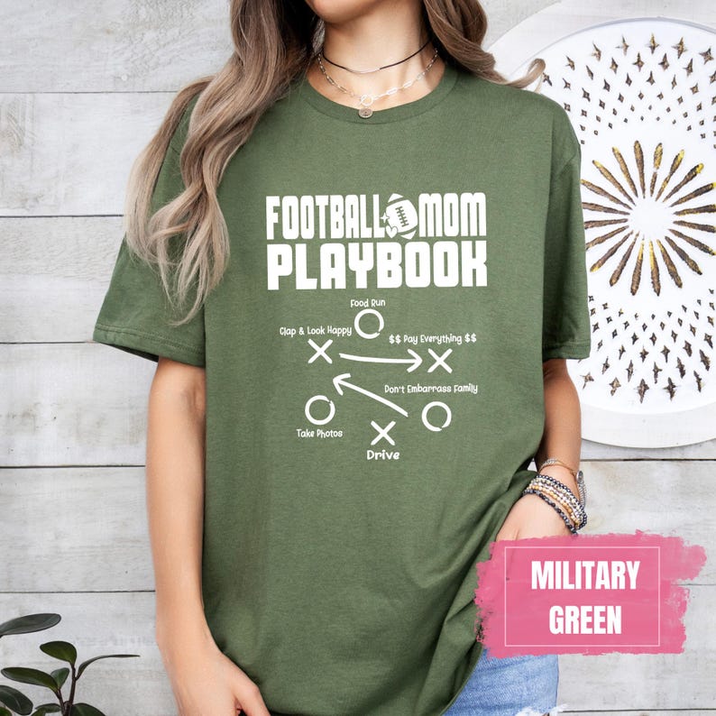 May include: A green t-shirt with the text "Football Mom Playbook" and a football play diagram. The text "Military Green" is in a pink box at the bottom of the image.