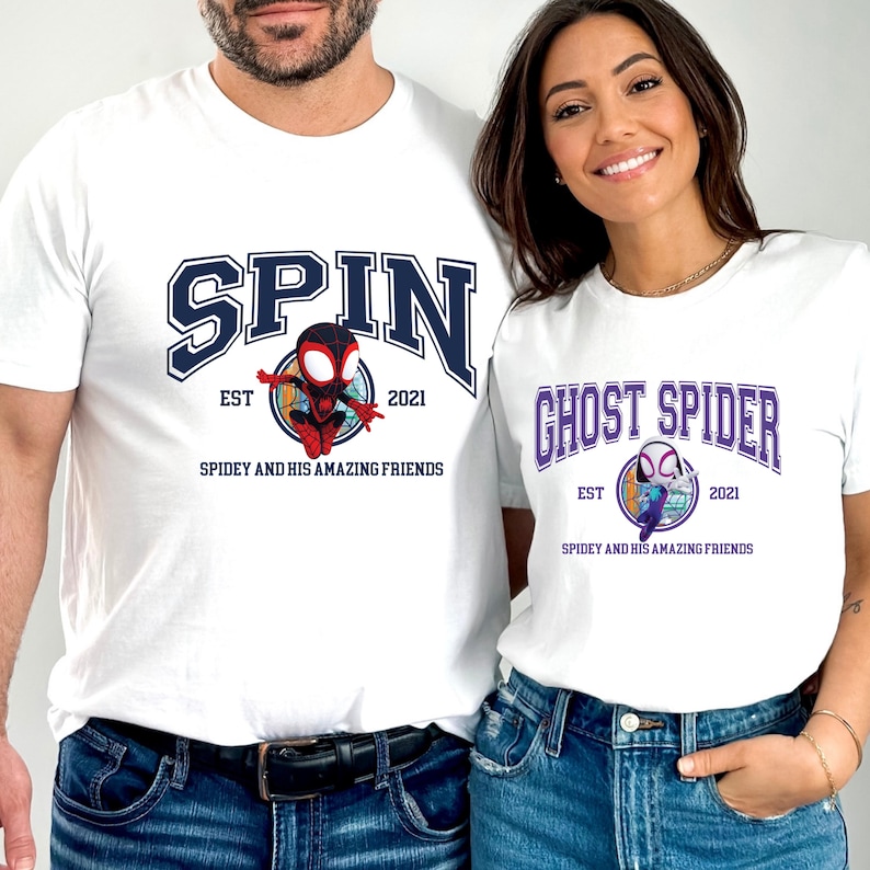 Pu&ograve; includere: T-shirt bianche con grafiche. Una maglietta presenta "SPIN" in lettere blu navy con un personaggio dei cartoni animati e la scritta "SPIDEY AND HIS AMAZING FRIENDS". L'altra maglietta dice "GHOST SPIDER" con un design simile.