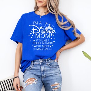 May include: Royal blue t-shirt with the text "I'M A Disney MOM" in white, along with a castle graphic and heart accents. The shirt also includes the phrase "IT'S LIKE A REGULAR MOM BUT MORE MAGICAL".