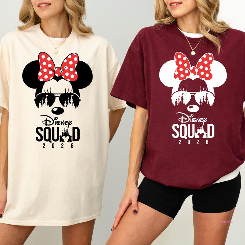May include: Two t-shirts, one cream and one burgundy, each featuring a Minnie Mouse graphic. The graphic includes a red polka dot bow, sunglasses, and the text "Disney Squad 2026".