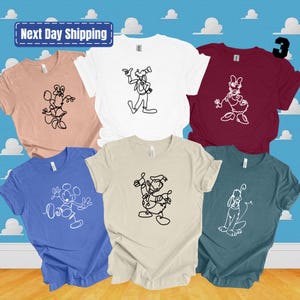 May include: Set of six t-shirts featuring different Disney characters in a single line drawing style. The shirts are in various colors, including white, beige, pink, blue, teal, and maroon.