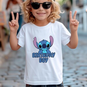 May include: White t-shirt with a blue Stitch character and the text "Birthday Boy".