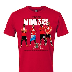 Könnte beinhalten: Rotes T-Shirt mit einer Grafik von fünf Fußballspielern, die Trophäen halten, und dem Text "13 TIMES CUP WINN3RS" und "1909 1948 1963 1977 1983 1985 1990 1994 1996 1999 2004 2016 2024".