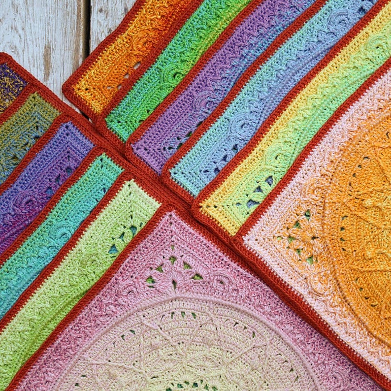 May include: A rainbow crochet blanket with a variety of colors and textures. The blanket is made up of multiple squares, each with a different design. The squares are joined together with a red border.