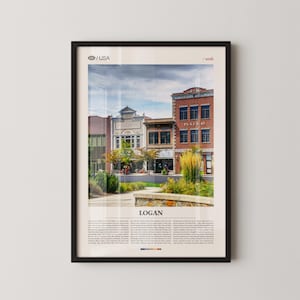 May include: Framed print featuring a street scene in Logan, Utah, USA. The image showcases a row of buildings with architectural details, including a brick building with the text "Plaza 45". The sky is overcast, and the print is in a black frame.