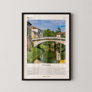 May include: Framed print featuring a scenic view of Vicenza, Italy. The image showcases a stone bridge over a river, with buildings and lush greenery in the background. The word "VICENZA" is printed at the bottom of the image.