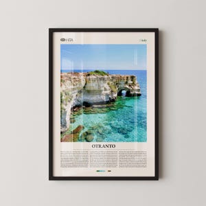 Puede incluir: Impresión enmarcada que presenta un paisaje costero en Otranto, Italia. La imagen muestra acantilados blancos, agua turquesa y un cielo azul claro. La impresión incluye el texto "OTRANTO" y texto descriptivo adicional.