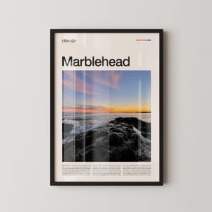 May include: Framed poster featuring a coastal scene at sunset. The word "Marblehead" is displayed in large, bold letters above a photograph of waves crashing against rocks under a colorful sky. The text "USA" is at the top.