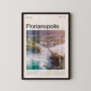 May include: Framed poster featuring an aerial view of Florianopolis, Brazil, with the city's name in bold black letters. The image showcases a coastal landscape with a beach, ocean waves, and lush green vegetation. The poster is encased in a black frame.