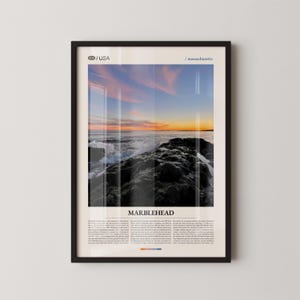 May include: Framed print featuring a coastal scene at sunset. The image captures waves crashing against dark rocks, with a vibrant sky of pinks, blues, and oranges. The text "MARBLEHEAD" is displayed below the image, along with additional text.