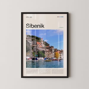 Può includere: Poster incorniciato con una vista panoramica di Sebenico, Croazia. L'immagine mostra una città costiera con edifici colorati, una chiesa con un tetto a cupola rossa e barche sull'acqua. Il poster include il testo "Sibenik" e "/ croatia".