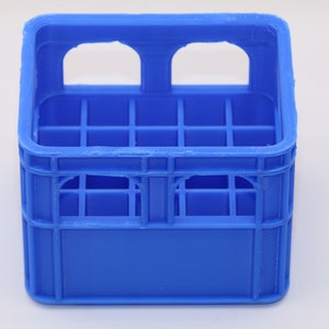 Könnte beinhalten: Ein blauer Plastikkasten mit einem Gittermuster und zwei offenen Griffen an der Oberseite.