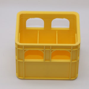Könnte beinhalten: Ein gelber Plastikkasten mit sechs Fächern und zwei Reihen von Öffnungen oben und unten.