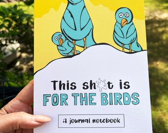 May include: A journal notebook with a yellow background and a cartoon illustration of three blue birds. The notebook cover has the text "This sh*t is FOR THE BIRDS" in black and teal lettering, with the words "A journal notebook" below.