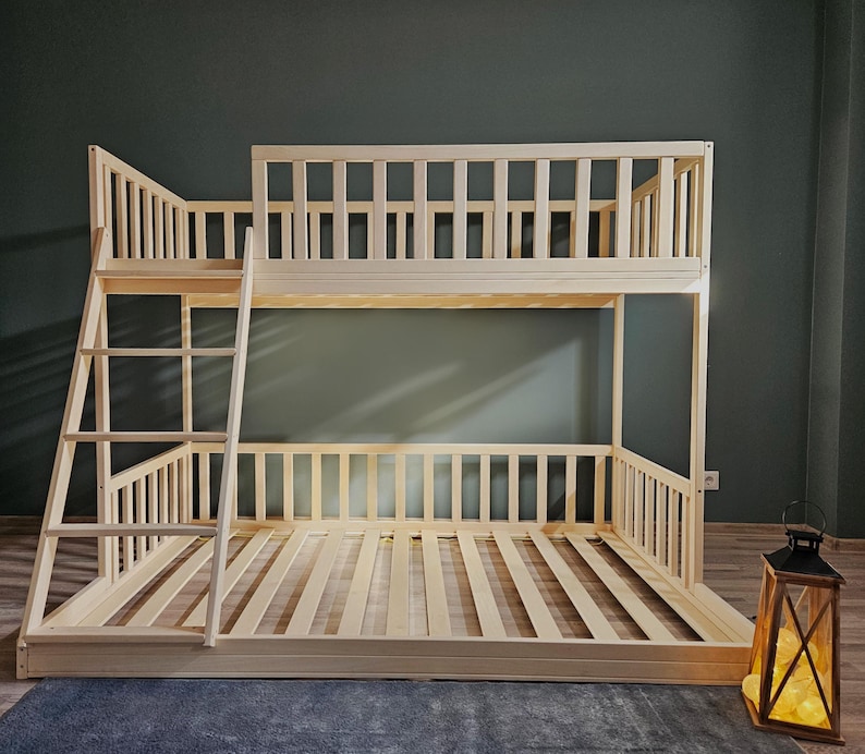 Puede incluir: Una litera de madera con una escalera en el lado izquierdo. La cama est&aacute; hecha de madera natural y tiene un dise&ntilde;o simple.