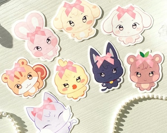 Könnte beinhalten: Satz mit acht Comic-Tieraufklebern mit rosa Schleifen. Jeder Aufkleber zeigt ein anderes Tier, darunter ein Kaninchen, ein Hund, eine Katze, ein Huhn, ein Eichhörnchen, ein Bär und zwei verschiedene Katzen. Die Aufkleber sind auf weißem Papier gedruckt und haben eine glänzende Oberfläche.