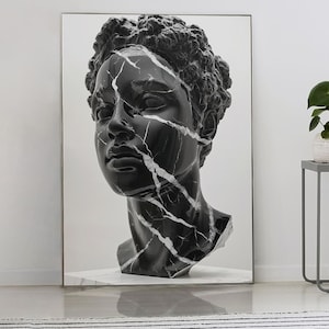 Può includere: Una stampa in bianco e nero di un busto classico con un effetto marmo screpolato. L'opera d'arte è appoggiata a una parete bianca, accanto a due tavolini, una pianta e una lampada. Un tappeto a righe bianche e nere è sul pavimento.