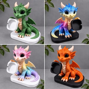 Könnte beinhalten: Eine Sammlung von vier Drachenfiguren, jede mit strukturiertem Körper, großen schwarzen Augen und Hörnern. Die Drachen sind in Grün, einem Blau-Gelb-Verlauf, einem Rosa-Blau-Verlauf und Orange dargestellt und halten jeweils ein quadratisches Tablett.
