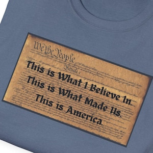 May include: A blue t-shirt with a print of the beginning of the US Constitution. The text reads "We the People" and "This is What I Believe In... This is What Made Us. This is America."