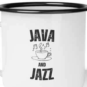 Op de afbeelding: Witte emaille mok met een zwarte rand. De mok heeft een zwarte afbeelding met de tekst "JAVA AND JAZZ" met een gestileerde koffiekop en muzieknoten.