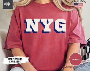 May include: A crimson red t-shirt with a white "NYG" graphic in a collegiate style font. The shirt is made of a soft, comfortable material and has a relaxed fit.  More colours are available.  Printed in the USA.