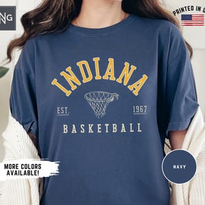 May include: Navy blue t-shirt with a yellow graphic of a basketball hoop and the text "INDIANA EST. 1967 BASKETBALL".