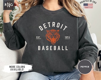 May include: A charcoal grey sweatshirt with a vintage-style graphic of a tiger and the text "DETROIT BASEBALL EST. 1894".