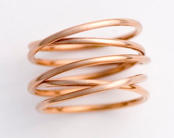 May include: A rose gold ring made of multiple thin bands twisted together.