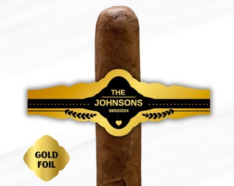 Könnte beinhalten: Goldfolien-Zigarrenband mit schwarzen und goldenen Akzenten. Das Band trägt die Aufschrift "THE JOHNSONS 08/02/2024".