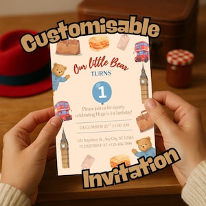 May include: A birthday invitation with a bear theme, featuring illustrations of a London bus, Big Ben, and a teddy bear. The text reads "Our little Bear Turns 1" with party details. The invitation is customisable.