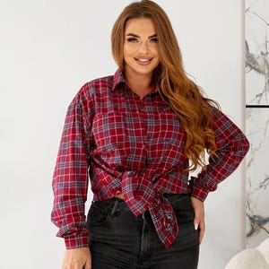 May include: A red and blue plaid flannel shirt with long sleeves and a button-down front. The shirt is tied at the waist.