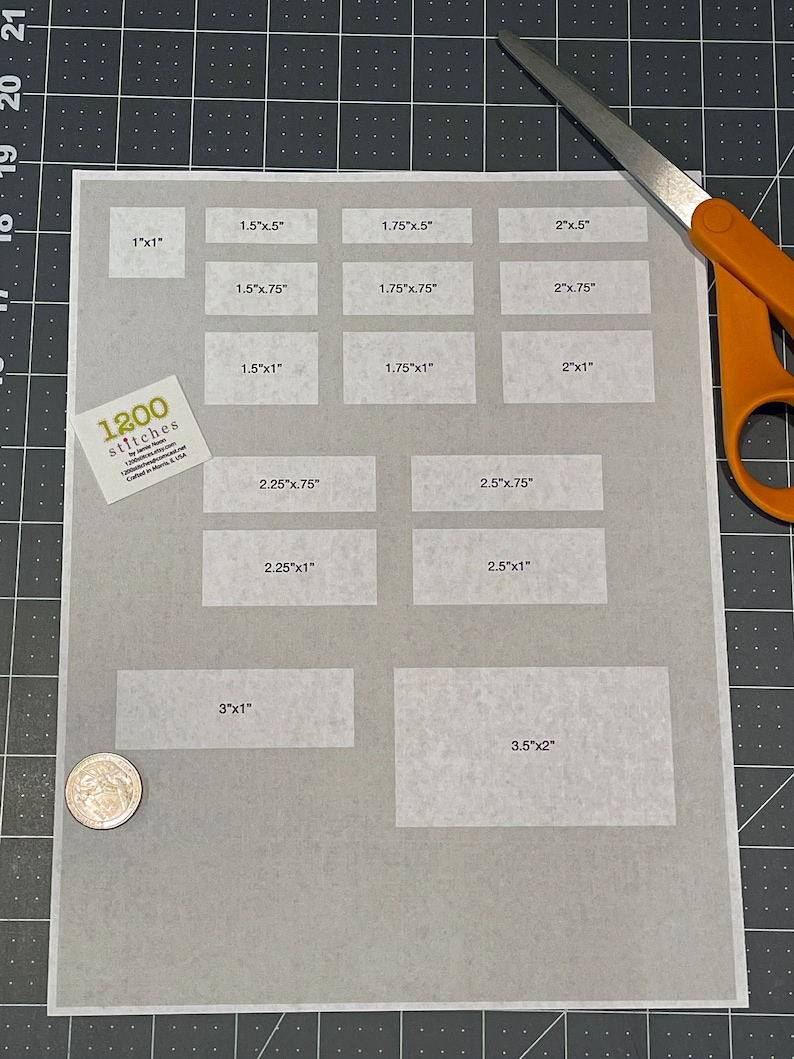 Pu&ograve; includere: Un foglio di carta bianco con una griglia di rettangoli etichettati con diverse misure in pollici. Il foglio &egrave; su una superficie di griglia nera. Il testo "1200 stitches" &egrave; visibile nell'angolo in basso a sinistra.