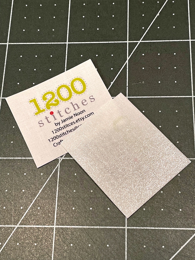 Pu&ograve; includere: Un biglietto da visita bianco con testo giallo che dice "1200 stitches by Jamie Noon 1200stitches.etsy.com Craft"