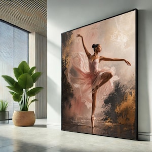 Op de afbeelding: Grote ingelijste canvas kunstdruk toont een ballerina in een roze jurk, en pointe. Het kunstwerk heeft een zacht kleurenpalet van roze, goud en bruin, met een textuurrijke, schilderachtige stijl. De ballerina staat in een sierlijke pose, armen uitgestrekt.
