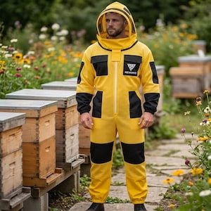 May include: A yellow beekeeping suit with black accents, including pockets and sleeve cuffs. The suit features a hood with a mesh face covering and the "REVOKO" logo. The beekeeper suit is designed for protection while working with bees.