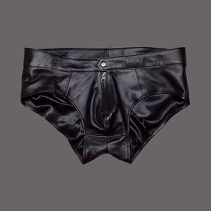 May include: Black leather underwear with a front zipper and button closure. The underwear has a low-rise waist and a satin lining. The garment is designed with a classic brief cut.