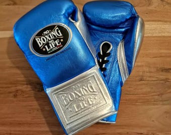 May include: Pair of blue boxing gloves with silver accents. The gloves have the text "NO BOXING NO LIFE" on the wrist and the top of the glove. The gloves are made in Mexico.