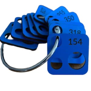 May include: Blue plastic ring gauge with different sized holes. The holes are labeled with the following measurements: .154, .318, .350, .255, .153.