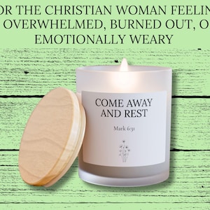 Könnte beinhalten: Eine Kerze im Milchglas mit brennendem Docht und einem hellen Holzdeckel. Das Etikett trägt die Aufschrift: FOR THE CHRISTIAN WOMAN FEELING OVERWHELMED, BURNED OUT, OR EMOTIONALLY WEARY. COME AWAY AND REST. Mark 6:31. Unter dem Text ist eine Blumenzeichnung.