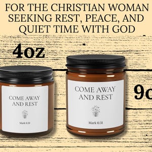 Könnte beinhalten: Zwei bernsteinfarbene Glaskerzen mit schwarzen Deckeln und weißen Etiketten. Die Etiketten tragen den Text "COME AWAY AND REST" und "Mark 6:31" mit einer kleinen Blumengrafik. Das Bild zeigt eine 4oz-Kerze und eine 9oz-Kerze mit Text darüber.