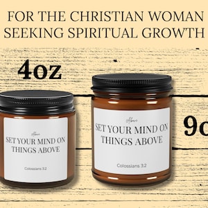May include: Two amber glass candle jars with black lids and white labels. The labels feature the text "SET YOUR MIND ON THINGS ABOVE" and "Colossians 3:2". The jars are labeled as 4oz and 9oz. The top text reads "FOR THE CHRISTIAN WOMAN SEEKING SPIRITUAL GROWTH".
