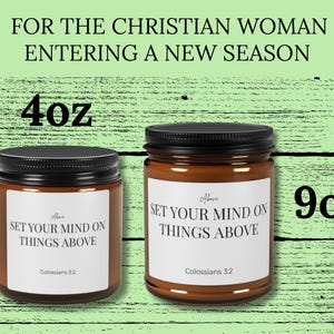 May include: Two amber glass candle jars with black lids and white labels. The labels read "SET YOUR MIND ON THINGS ABOVE" and "Colossians 3:2". The jars are labeled "4oz" and "9oz". The text "FOR THE CHRISTIAN WOMAN ENTERING A NEW SEASON" is visible.