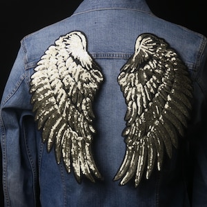 May include: A denim jacket with two large sequined angel wings sewn on the back. The wings are silver and black.